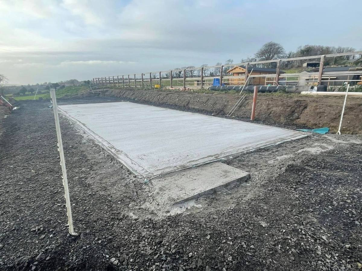 GS Services — excavator on groundwork site, Isle of Man